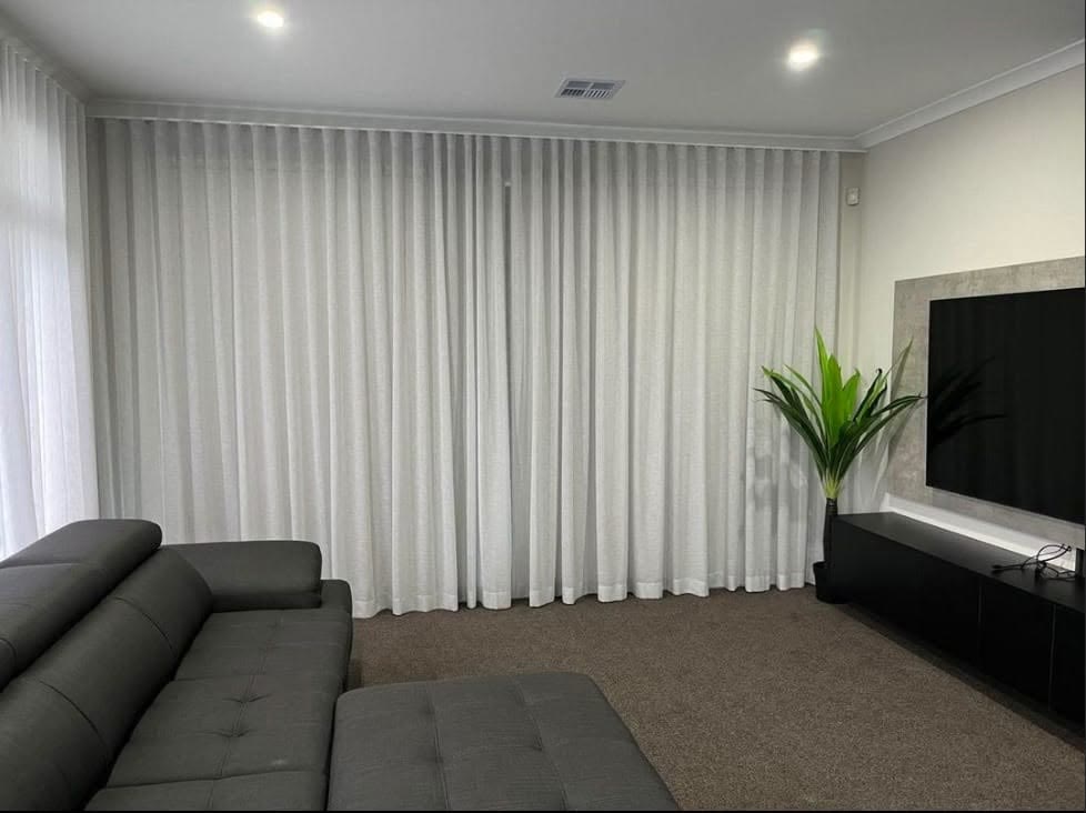 White sheer curtains in a carpeted media room
