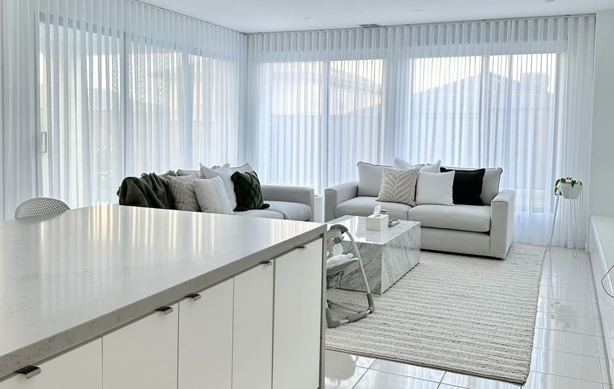 Floor-to-ceiling white sheers in an open-plan living area