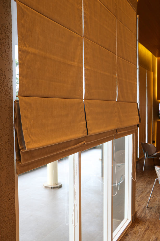 Mustard roman blinds over a sliding door