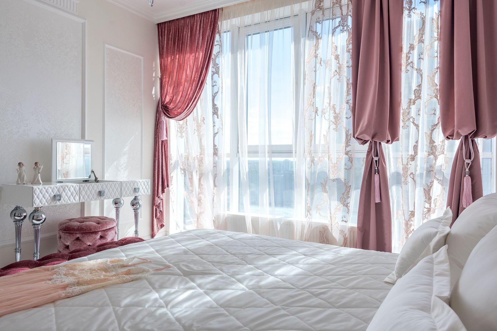 Dusty-rose curtains and patterned sheers in a bedroom