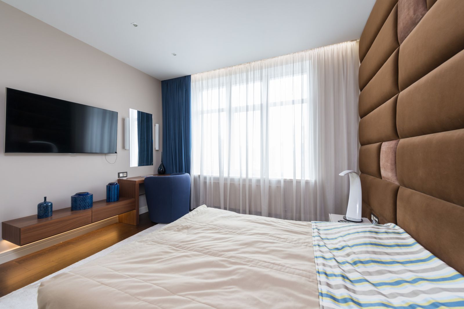 Blue curtains with white sheers in a modern bedroom