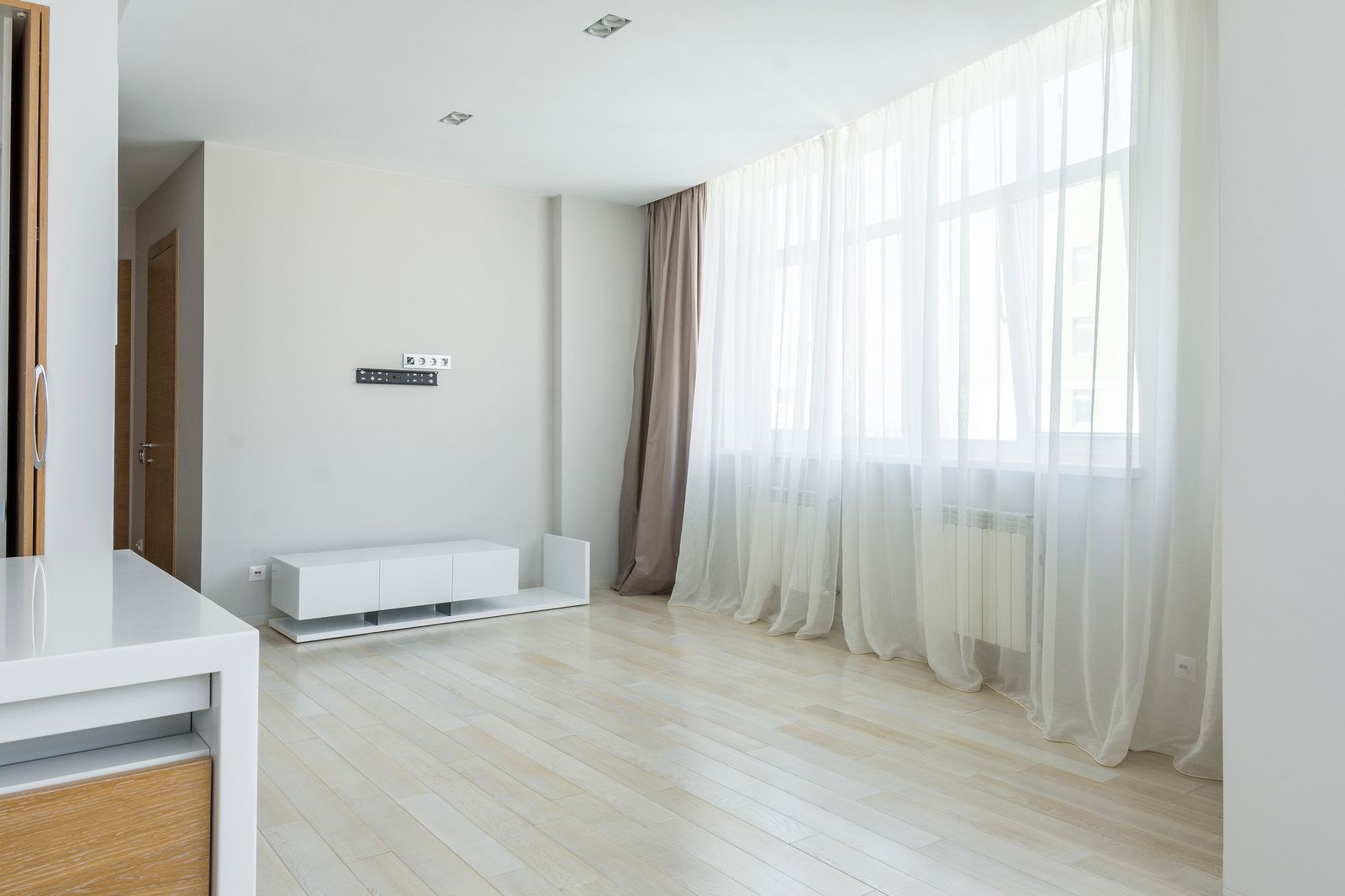 Sheer and blockout curtains layered on a tall window