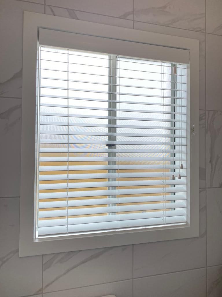 White venetian blinds in a tiled bathroom